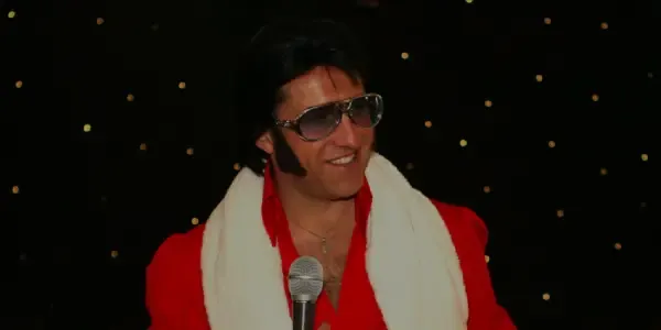 Elvis impersonator Marcus Hallows performing on stage.